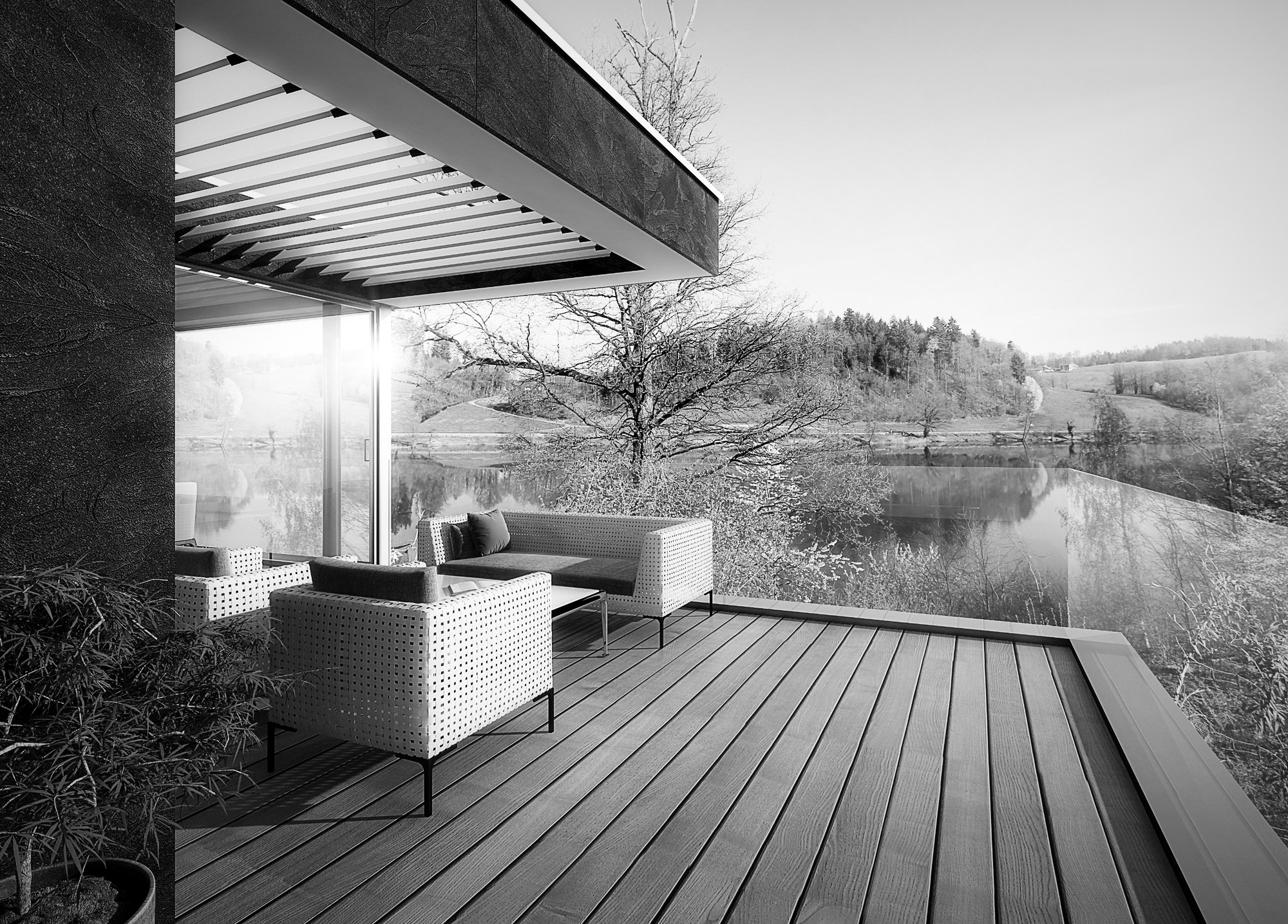 Holzterrasse mit Loungemöbeln und Blick auf den See
