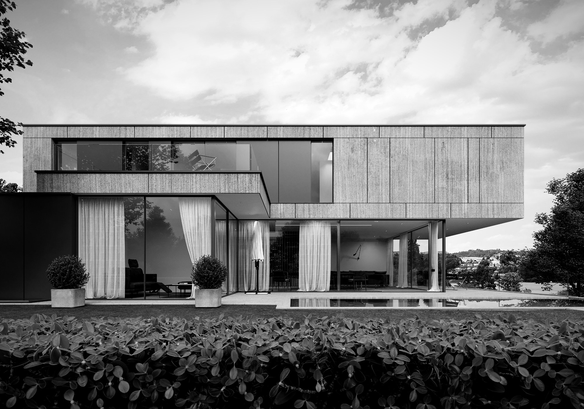 Villa mit Fassade in Betonoptik, grossen Glasfronten und Pool, im Hintergrund der See