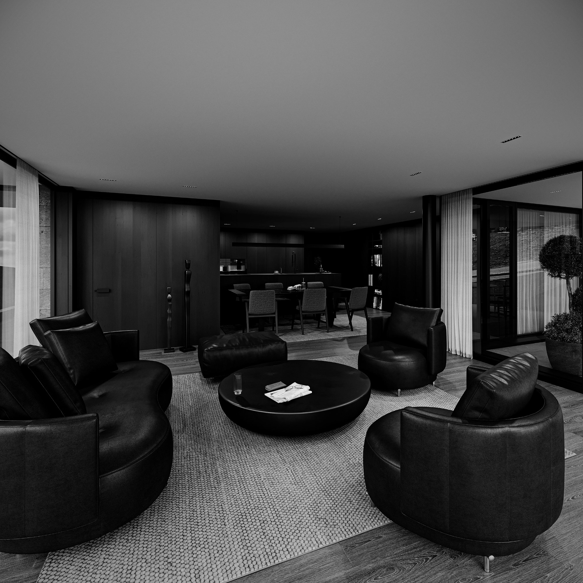 Lounge mit schwarzen Ledersesseln und Blick zur Küche
