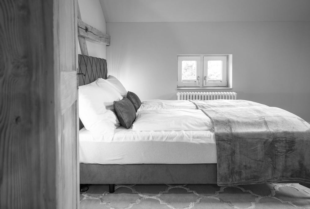 Schlafzimmer unter dem Dach mit sichtbarem Holzbalken