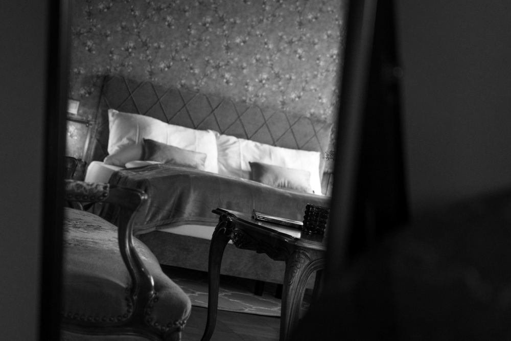 Schlafzimmer mit floraler Tapete und antikem Mobiliar