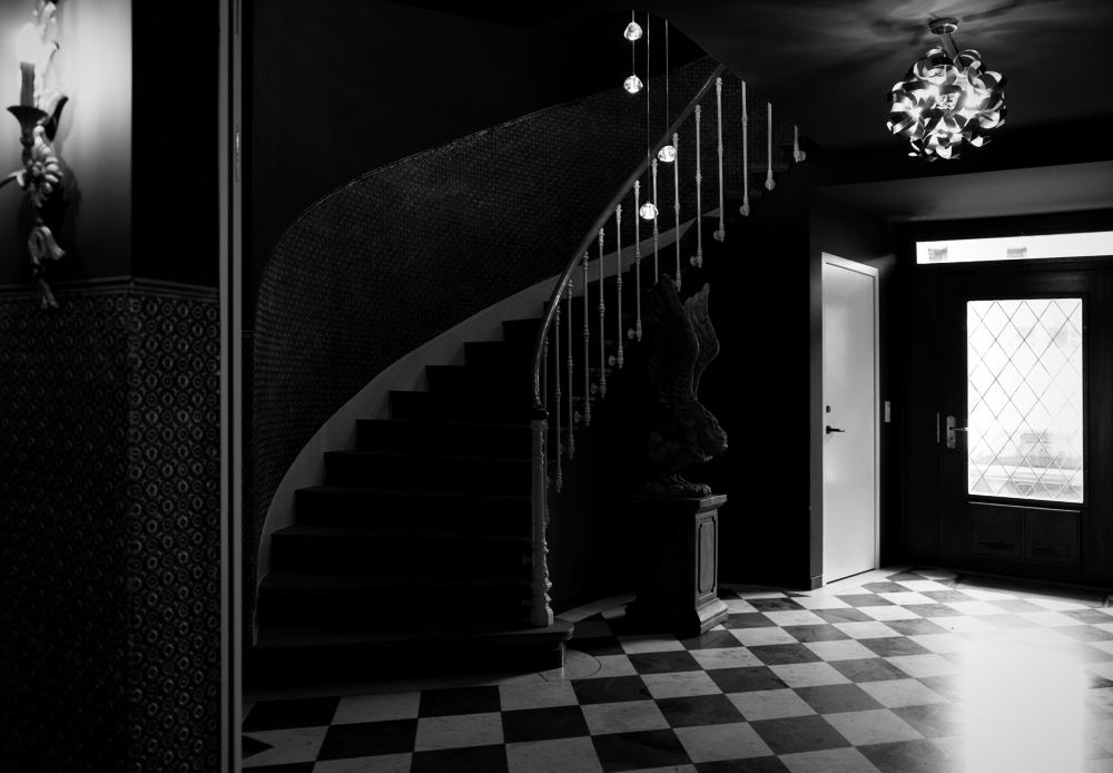 Eingangshalle mit geschwungener Treppe und Schachbrettboden