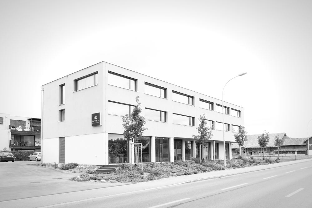 Motel WYNA mit Putzfassade, Bandfenstern und verglastem Erdgeschoss